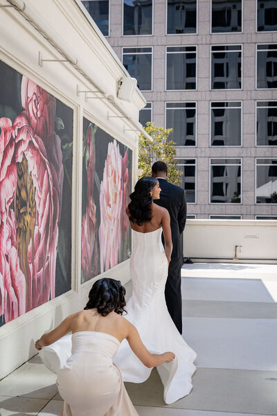 a bridesmaid spreads the train of a bride at her uptown charlotte wedding