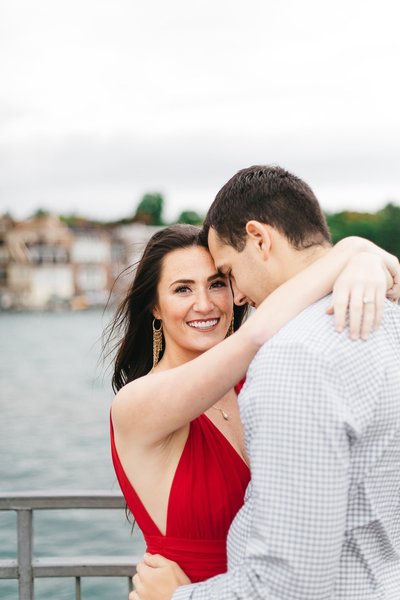 Engagement portrait on a dock with views of a lake in the background