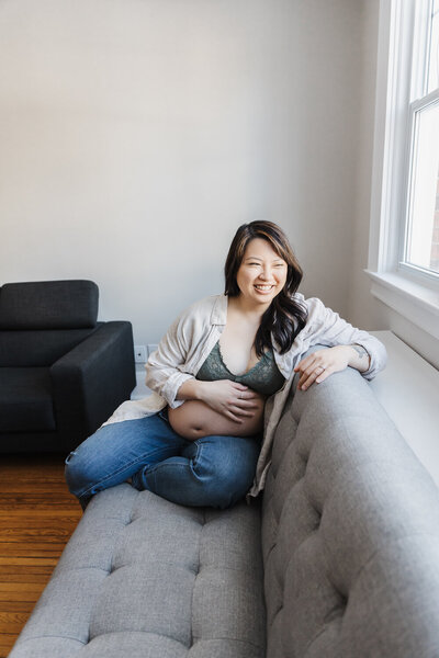 Beautiful pregnant woman sitting on her couch