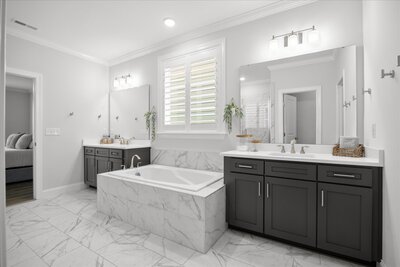 Primary ensuite dual vanity bathroom, with semi frameless walking shower and soaker tub home in Wilmington NC