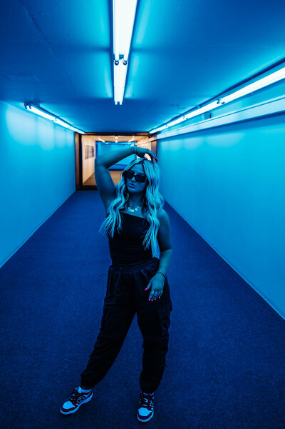 Model posing in a neon lit room/underground tunnels in Bricktown, OK