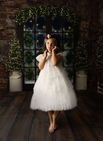 Christmas themed photo of a little girl in a white frilly dress