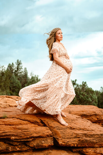 Maternity mom cradling belly in Sedona, Arizona