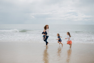 mum-running-with-children-at-beach