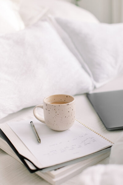 an image of a mug on a stack of notebook on a website for online motherhood group coaching for moms of color
