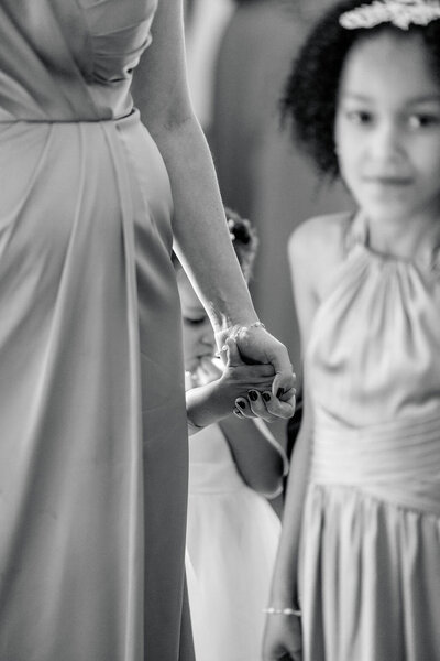 Rhode Island Wedding Photographers | A black and white image of a woman holding a child's hand. A second child in a dress stands beside them.