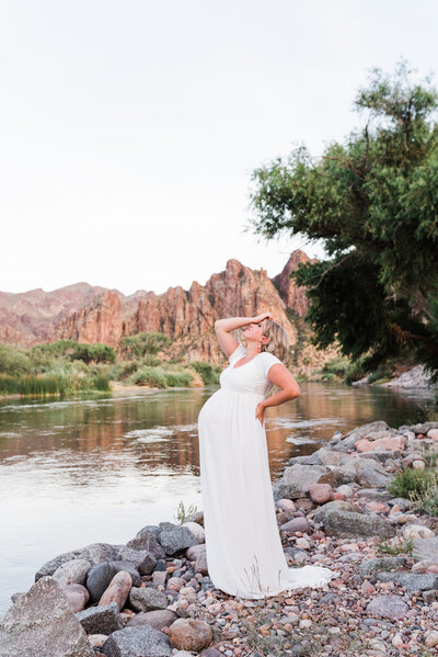 maternity session white dress mom holding head by river