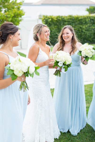 bride with champagne laughing with bridesmaids