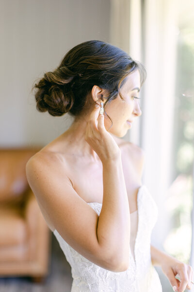 bride fixing earring at hayden lake country club