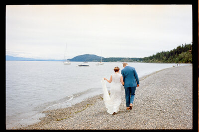 Bride and groom walking hand in hand.