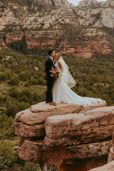 groom kissing bride on cliffis in sedona arizona