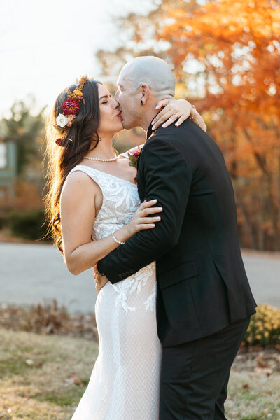 Kissing photos of wedding at crescent hotel in Eureka Springs with fall colors.