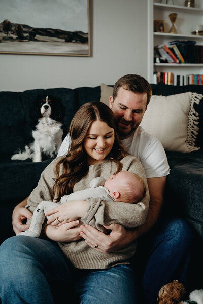 Newborn baby peacefully resting in parents' arms, capturing natural moments of love and warmth | Pittsburgh Lifestyle Newborn Photography