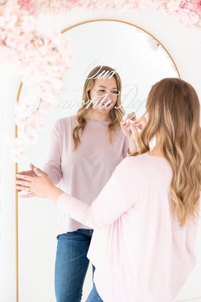 Woman writing calligraphy on a mirror