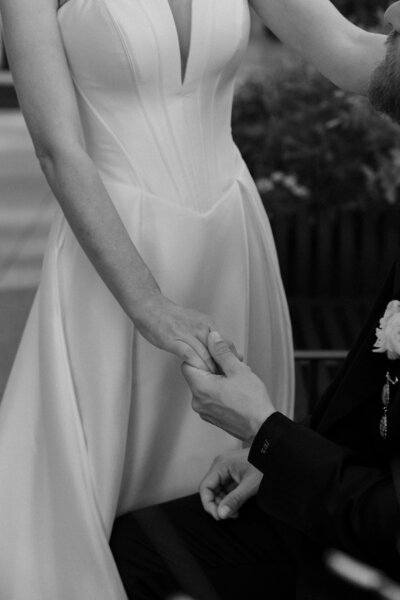 Bride and groom sharing a kiss under the wedding veil, captured in a tender and intimate moment, with the veil gently draped over them.