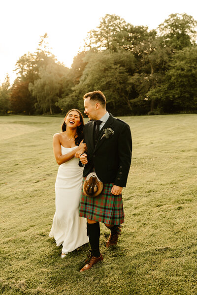 Bride and groom kiss under neon sign at alternative scottish wedding