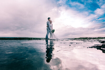 Bride and groom hugging each other in the ocean