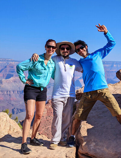 three people pose on a grand canyon hike to show the benefits of online strength training programs