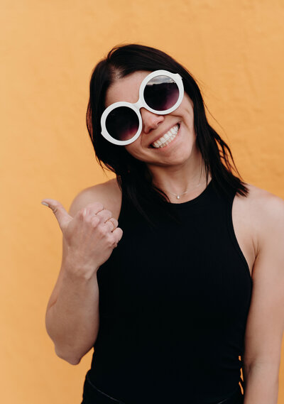 Kandice Jeppsen, Budgeting coach for the LIVE BIG Collective posing confidently with sunglasses on 
