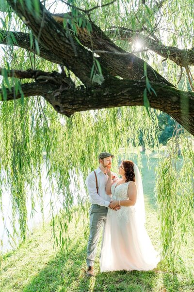 Newlyweds Mark and Emily underneath Carrigan Farms' willow tree captured by Charlotte NC wedding photographer