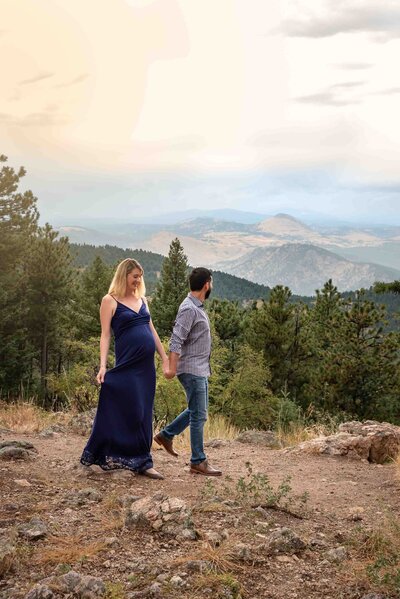 expecting couple walking in mountains