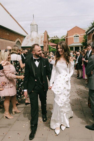 bride and groom hold their puppy on wedding day