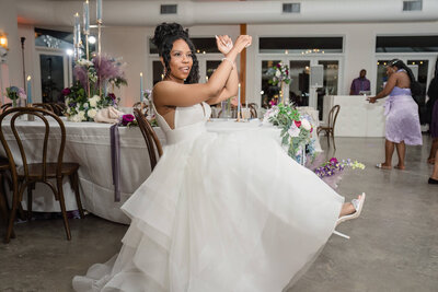 Joyful bride twirling in her wedding gown during a fun-filled reception planned by a luxury wedding planner.