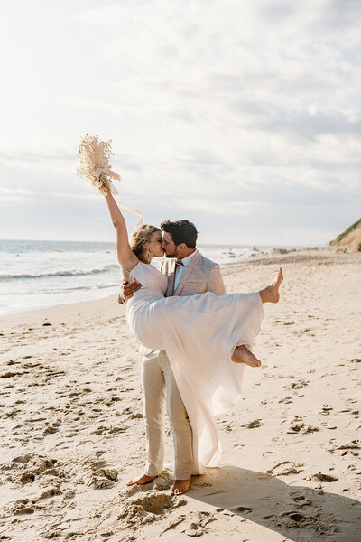 bride and groom kiss on beach