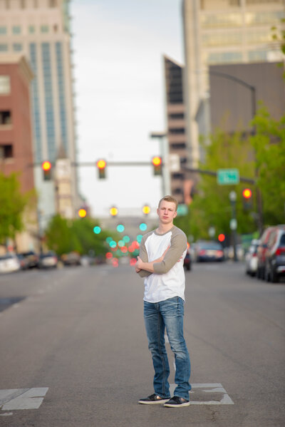 Senior boy standing in an intersection in downtown Boise during senior portraits with photographer Tiffany Hix