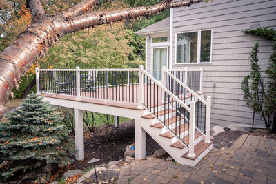 A PVC deck with white trim and stair risers, and black-and-white aluminum railing. 