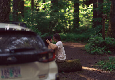 couple sitting next to a car having a moment
