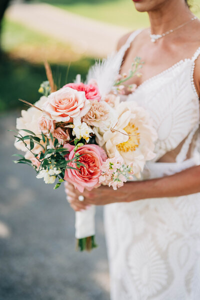 woman in white dress holding pink bouquet 