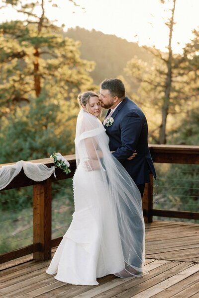 Bride closes eyes as groom kisses her during intimate Airbnb wedding.