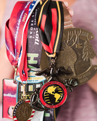 A close-up of marathon medals earned by Janeil Anderson, Montana stationery designer and dedicated runner behind Seventh and Anderson.
