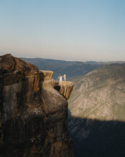bride and groom running on beach cliff
