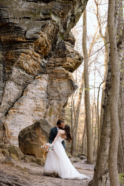 Bride holding up a bouquet of flowers during a beach elopement in Michigan.