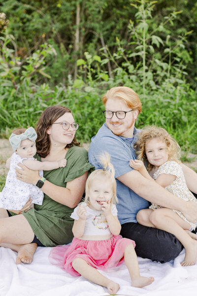 a family sitting on a picnic blanket