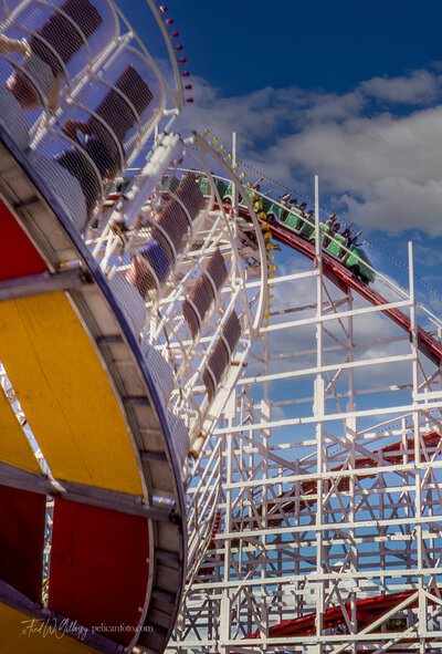 Santa Cruz Beach Boardwalk’s classic Round Up ride with its famous Giant Dipper wooden roller coaster background.