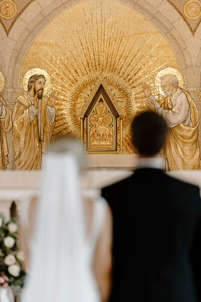 a bride and groom participating in a Catholic wedding