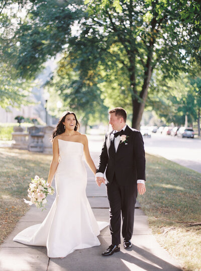 bride and groom walking in Rochester, NY at the Strathallen Hotel