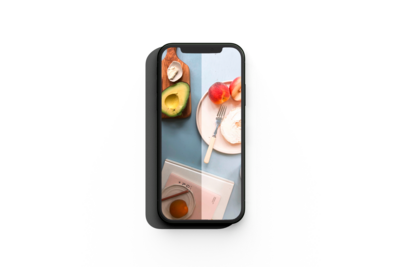 mockup of a smartphon showcasing the preset action on a blue table with a pink plate filled with peaches, a wooden tray with avocado and some books