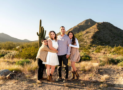 Phoenix family hugging each other close in the Arizona desert
