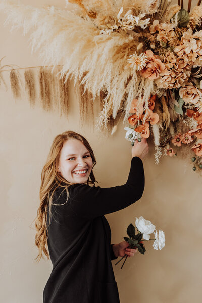 emma fixing flowers at a wedding
