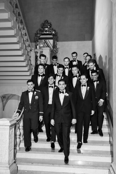 Black and white photo of groomsmen walking down stairs
