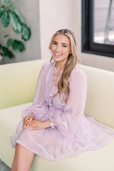 Headshot of Annie in a green dress in front of a floral wall