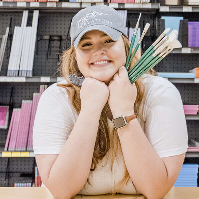 Elyse Stokes Smiling in Art Store with Brushes