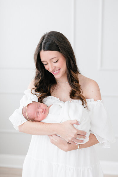 Portrait of a new mom holding her sleeping baby boy by northern kentucky newborn photographer missy marshall