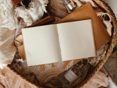 Blank book sits open atop boho-colored items
