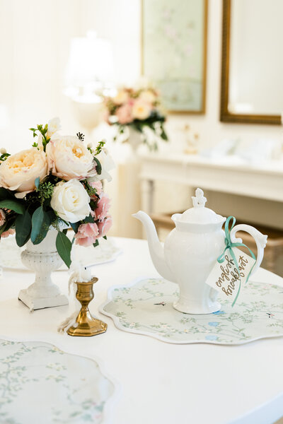 Beautiful tea pot and flower arrangement  set on a pastel table.