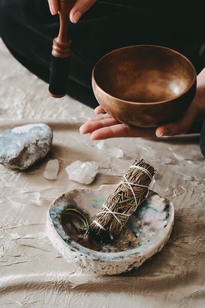 a woman's hand holds a prayer bowl abo